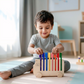 Child playing with a colorful wooden toy in a bright room